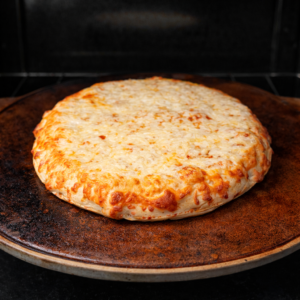 Cheese pizza baking on a preheated pizza stone in a home oven